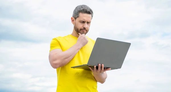 Grübelnder Mann Arbeitet Online Laptop Auf Himmelshintergrund — Stockfoto