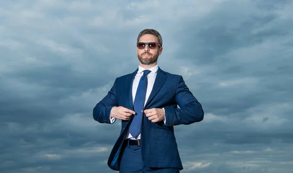 Businessman Wearing Sunglasses Sky Background Grizzled Businessman Buttoning Suit Jacket — Stock Photo, Image