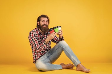 Sıradan bir sabah. Adam kağıt bardaktan sıcak çay içiyor. Günaydın. Enerjik, sıcak içecek. İlham almak için kahve lazım. Mutlu sakallı adam sabah kahvesini içiyor..