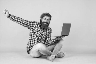 Harika bir sonuç elde ettim. Webinar ve iş eğitimi. Laptop kullanarak. Online öğrenme kavramı. Sosyal mesafe. Defteri olan özenli bir adam. Kareli tişörtlü sakallı adam internette ders dinliyor..