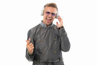 Heyecanlı iş adamı, beyazlar içinde izole edilmiş bir şekilde şarkı söylüyor. Kulaklıkla müzik çalan mutlu bir adam. Kaygısız şarkıcı müziğe şarkı söylemekten hoşlanır..