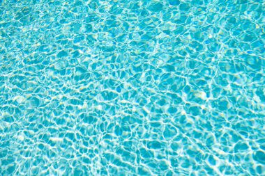 Yazın dalgalı okyanus suyunun mavi arkaplanı.