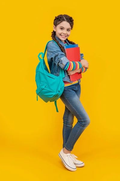 幸せな青年女子高生黄色の背景 思春期の少女は学校に戻る 思春期の生徒は本を持っています 9月1日 知識の日 — ストック写真