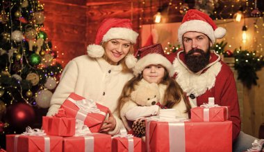 Mutlu Noeller ve mutlu yıllar. Kış tatili Alışveriş satışları. Mutlu noeller. Baba ve anne kızı sever. Mutlu aile yeni yılı kutluyor. Noel Baba şapkalı küçük bir çocuk ve ailesi..