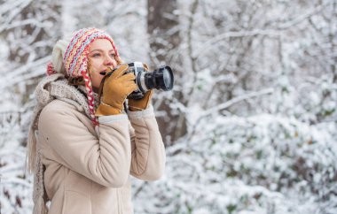 Büyüleyici solgunluğun ve dondurucu kış atmosferinin tadını çıkar. Kış hobisi. Çarpıcı kış fotoğrafları çekiyor. Fotoğraflarla kar manzarasının güzelliğinin tadını çıkar. Profesyonel kameralı kadın fotoğrafçı.