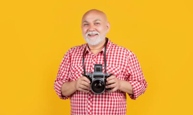 Sarı bankta retro fotoğraf makinesi olan yaşlı adam memnun oldu..