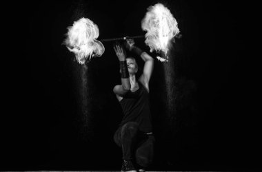 Yüksek enerjili ateş dansçısı. Şehvetli ateş dansçısı karanlıkta alevli bir değnek çeviriyor. Yangın gösterisi. Sanat sergisi. Sopa çevirme. Tatil kutlaması. Gece partisi. Dans ederek yaşamak.
