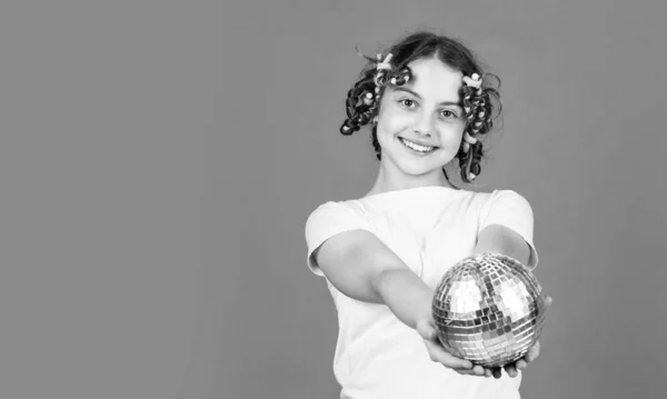 Fancy teen. Hairstyle for disco party. Have fun. Retro party. Child hold golden disco ball. Cheerful girl with disco ball. Fashion kid posing with curlers in hair. Night club. Hairdresser salon.