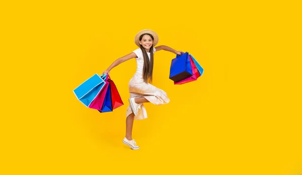 Glückliches Teenie Mädchen Das Mit Einkaufstaschen Auf Gelbem Hintergrund Läuft — Stockfoto