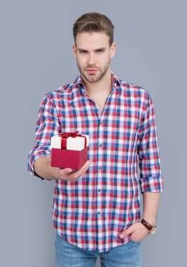 Şu anki satış konsepti. Satıştaki adam gri arka planda izole edilmiş. Stüdyoda erkek için hediye satışı. Erkek için doğum günü hediyesi. satış ve indirim.