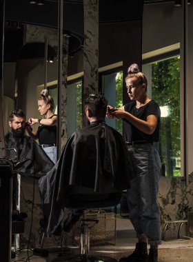 Hipster, berber dükkanında saç kesiminde siyah saçlı beyaz bir tip..