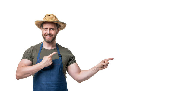 Кавказский человек в шляпе и фартуке изолирован на белом фоне. указывать пальцем на пространство для копирования.