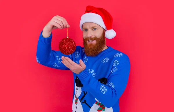 new year decoration. cheerful bearded man hold new year decoration isolated on red background. man with new year decoration in studio.