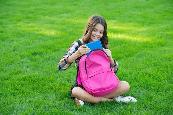 Menina Adolescente Feliz Levando Livro Fora Bolsa Escola Sentado Grama — Fotografia de Stock