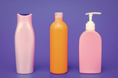 Multicolor plastic containers for liquid toiletries and cosmetic products in row blue background copy space, bottles.