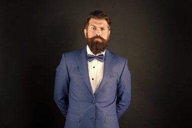 Smokin papyonlu ciddi bir adam. Siyah arka planda resmi giyinmiş bir beyefendi. erkek resmi moda.