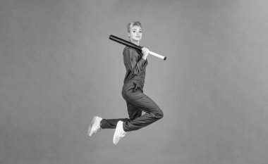 Başarı. Spor ve oyunlar. Turuncu arka planda kriket oyuncusu. Bayan elinde spor malzemesi ya da aksesuar tutuyor. Aktif kıyafet. Rounders maçı. Klimalı kadın sopayla zıplıyor. bayan beyzbol oyuncusu.