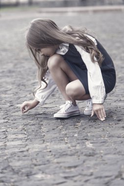 Oynamadan önce öğreniyorum. Dışarıdaki kaldırımda küçük bir çocuk resmi çiziyor. Okul modasına geri dönelim. Üniforma. Erken çocukluk eğitimi. Oyun okulu ve okuldan sonra. Eğitici oyunlar. Oyun zamanı.