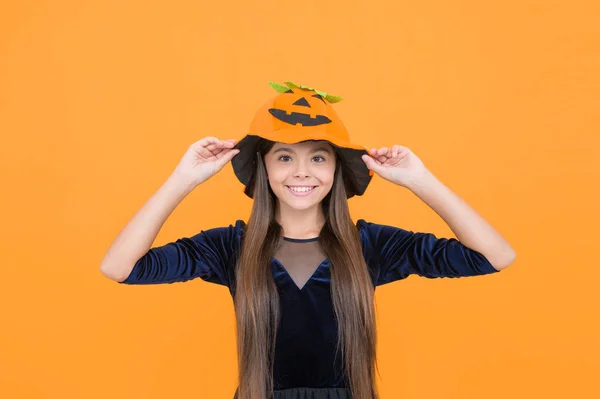 halloween girl in pumpkin hat. happy childhood. teen child in gourd hat. smiling kid wearing squash headwear. carnival costume party. trick or treat. celebrate the holiday. jack o lantern.