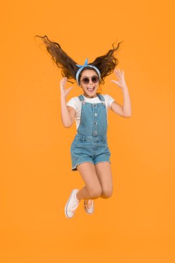 Kolaylığın tadını çıkar. Yaz tatili konsepti. Kız uzun kıvırcık saç güneş gözlüğü başörtüsü bağlı. Çocuk kıyafetleri butiği. Yaz aksesuarları. Yaz trendi. Küçük moda. Sevimli küçük çocuk moda kız.