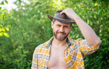 Kovboy şapkalı batı adamı. Kareli gömlekli batı kovboyu. Batı kovboyu batı şapkası giyiyor. Boşluğu kopyala.