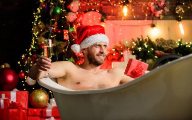 Saf zevk. Hijyenik mühendislik dükkanı. Lüks hijyenik malzeme. Yüksek kaliteli hijyenik malzeme. Lüks banyo. İndirim ve indirim. Adam yeni yılı kutluyor. Küvette uzanmış köpüklü şarap içiyor..