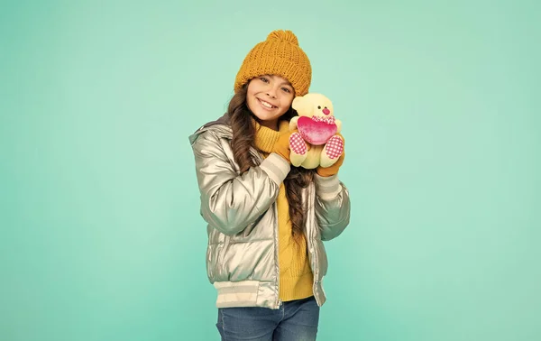 Kışın Giyinmiş Neşeli Genç Kız Mavi Arka Planda Oyuncak Tutuyor — Stok fotoğraf