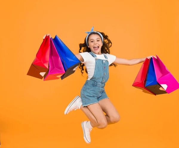 真正的快乐 成功购物后快乐的小女孩 精力充沛的孩子背着沉重的袋子跳了起来 礼品包装 网络星期一 加快它的总销量 童装时尚 销售和折扣 — 图库照片