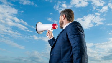 İş adamı gökyüzü arkaplanında hoparlörden anons yaptı.