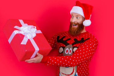 Yılbaşı hediyesiyle sürpriz bir adam. Mutlu noeller. Noel Baba, Noel hediyesini kırmızıda izole et..