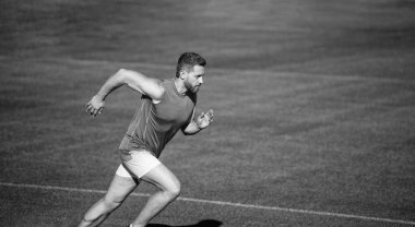 Enerjik atletik kaslı adam koşucu yeşil çimlerin üzerinde koşuyor, kopyalama alanı, başarı.