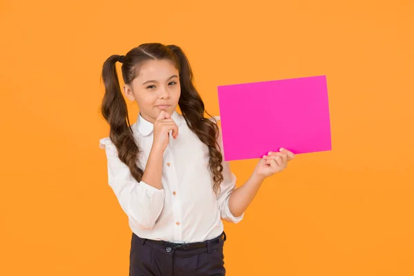 学校情報のため 黄色の背景に関する情報のために空のピンクの紙を保持している小さな子供 情報の通知を持つ小さな女の子 情報の拡散と知識の収集 コピースペース — ストック写真