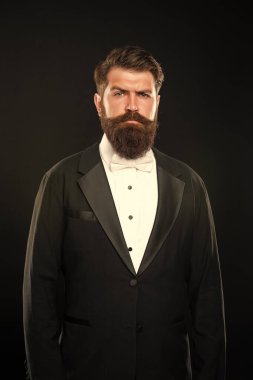 bearded man in tuxedo on black background, formalwear.