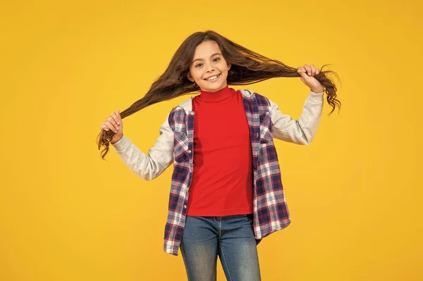 Szczęśliwy Dziecko Casual Styl Trzymać Długie Włosy Żółtym Tle Włosy — Zdjęcie stockowe
