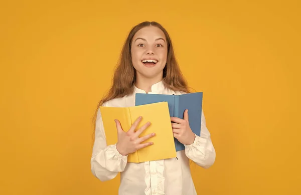 幸せなティーン女の子ホールドスクールワークブック上の黄色の背景 — ストック写真