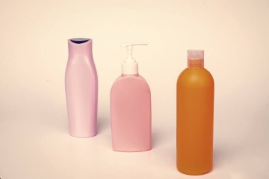 Plastic toiletry containers for liquid cosmetic products in row isolated on white, bottles.