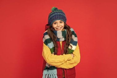 express positive emotion. winter fashion. happy kid with curly hair in hat crossing hands. female fashion model. teen girl in scarf. portrait of child wearing warm clothes.