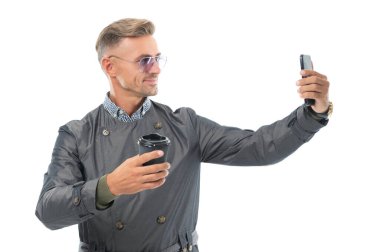 Mutlu gülümseyen iş adamı iş adamı iş telefonuyla selfie çeken iş adamı iş adamı iş adamı iş adamı yönetmeni beyaz, selfie 'de izole edilmiş kahve fincanı stüdyosu..