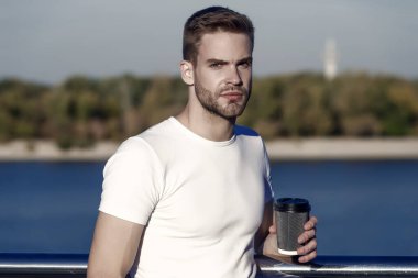 Paket kahve benim yaşam tarzım. Yakışıklı adam dışarıda kahve fincanı tutuyor. Genç adam yaz sabahı kahve içer. Nehir kıyısında kahve içiyorum..