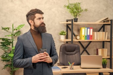 pondering brutal ceo in businesslike suit hold morning coffee cup at the office, to go.