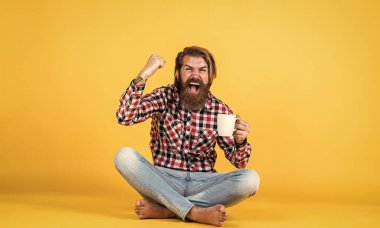 Kazandım. Enerjik, sıcak bir içecek. İlham için biraz kahveye ihtiyacım var. Güne mükemmel bir başlangıç. Mutlu sakallı adam sabah kahvesini içiyor. Adam fincandan sıcak çay içiyor. Günaydın sana..