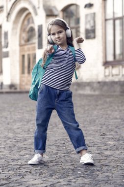 Macera orada bir yerde. Küçük gezgin parmağını ileri uzat. Küçük çocuk sırt çantasıyla müzik dinliyor. Çocukluk macerası. Macera tatili. Tatil gezisi. Seyahat ve seyahat tutkusu. Zihnini boşalt.