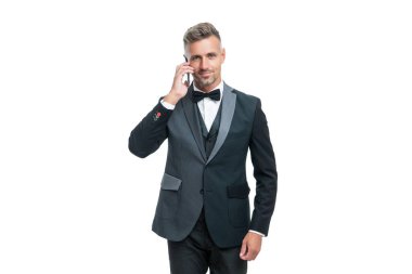 Smokinli girişimci, beyaz arka planda izole edilmiş akıllı telefondan konuşuyor..