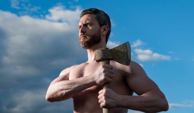 Baltalı üstsüz kaslı adam. Beyaz adam, baltayı tut. Gökyüzündeki vahşi adam.