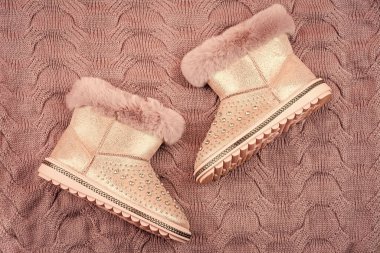 pair of fashionable leather ugg boots. ankle boots on knitted background. shoe store. shopping concept. female leather stylish footwear.