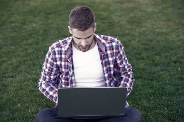 Modern teknolojiler. Öğrenci çayır üzerinde çalışıyor. Çevrimiçi iletişim. İnternette sörf yapmak. Dizüstü bilgisayara bakan adam. Yetenekli geliştirici. İş kurma. Millennial iş yaratıyor. Modern iş.