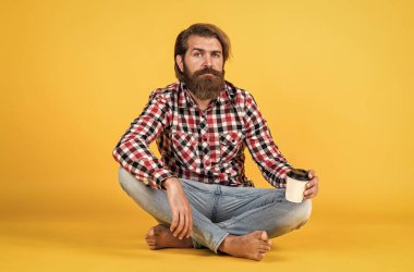 Kaygısız bir sabah. Bir fincan kahve ya da çay al. Yaşam tarzı konsepti. Kahveli yakışıklı hippi adam. Kahve molası veriyor. Yakışıklı olgun adam bardaktan içiyor.