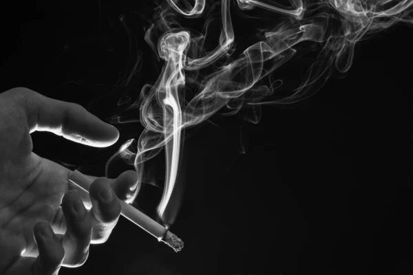 男性手拿着烟流暗黑背景色的香烟 — 图库照片