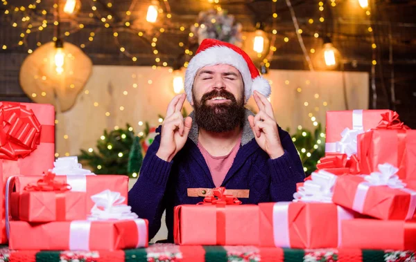 Hipster prepared gifts for family. Man bearded santa claus hat celebrate new year. Generous new year. Lot of gifts. Happy winter holidays. Hope for the best. Wrapped gifts with ribbons and bows.