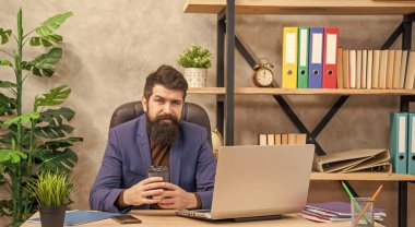 positive confident mature man freelancer use online computer communication at office holding coffee, modern life.